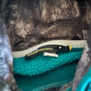 Teal Under Armour sweatshirt with camo letters, trim and inside the hood